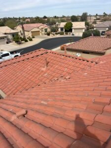 IMG_2326 - Desert Sands Contracting Overhead view of red clay tile roofs in a quiet suburban neighborhood with desert landscape in the distance under a clear sky.