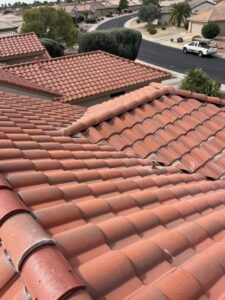 IMG_2327 - Desert Sands Contracting Close-up of red clay tiled roof on a suburban house, with more tiled roofs and a street in the background.
