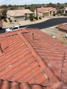 IMG_2329 - Desert Sands Contracting View from a red clay tiled roof overlooking a suburban neighborhood with beige houses, street, and a white pickup truck nearby.