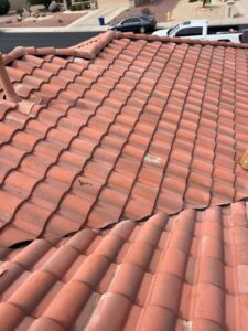 IMG_2332 - Desert Sands Contracting Clay tile roof with curved red tiles; street and parked cars visible in the background.