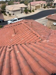 IMG_2336 - Desert Sands Contracting Aerial view of red clay tile roof from above, with beige desert suburb houses and a white pickup truck on the street below.